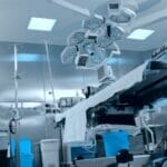 photo from a low perspective of an operating table with stainless steel lighting units above it