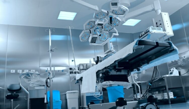 photo from a low perspective of an operating table with stainless steel lighting units above it