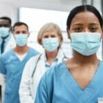 4 medical professionals wearing masks lined up