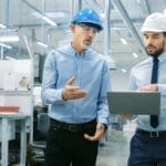 two men walking through manufacturing facility
