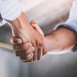 AEC team member and manufacturer shaking hands