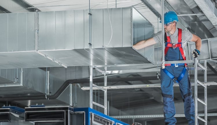 commercial hvac worker installing system